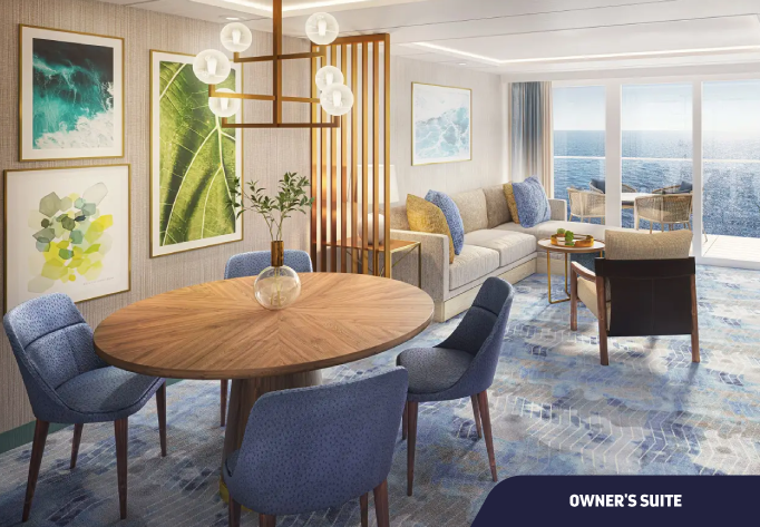 Foto da cabine Owner´s Suite com Mesa redonda, sofá, poltrona e vista da varanda para o mar